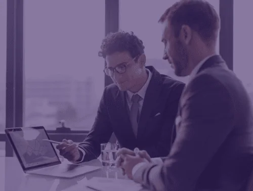 Two advisers reviewing company documents on a laptop